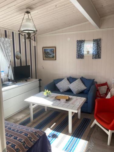 een woonkamer met een blauwe bank en een tafel bij Lugnt och centralt in Strömstad