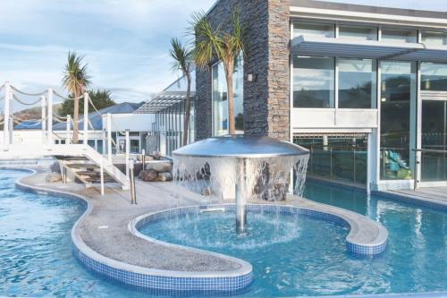 a pool with a fountain in front of a building at Weymouth Bay Holiday Static Caravan in Preston