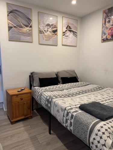 a bedroom with two beds and a wooden table at Brigstock3 in Thornton Heath