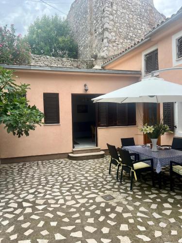 a patio with a table and an umbrella at Nesa Beach Front Apartment in Poreč