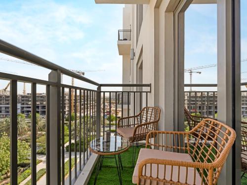 a balcony with two chairs and a table at The Town Square Suite Luxury 2BR Near Qudra Lake in Dubai