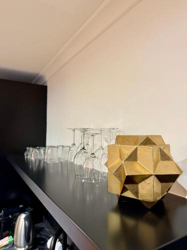 a counter with wine glasses and a gold box on it at ALFRED SUITES - Appart-Hôtel - Dijon - Centre Historique in Dijon