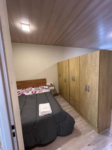 a bedroom with a bed and wooden cabinets at El Atardecer in Trapiche