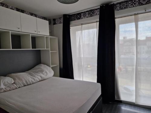 una camera da letto con un letto e una grande finestra di PapayaCalais a Calais