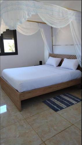 a bedroom with a bed with a canopy at Résidence DELIA in Diego Suarez