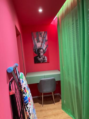 una stanza con pareti rosa e verdi e una sedia di Central Apartment a Tirana