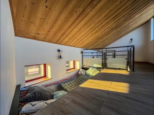 a room with a couch and a wooden ceiling at Loft Moderne Avec Jacuzzi Roft top Le B in Baccarat
