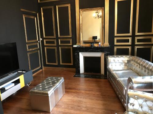 un soggiorno con un divano e una televisione di La gentilhommiere de Saumur a Saumur