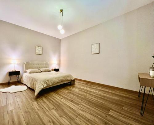 a bedroom with a bed and a wooden floor at ROUERGAT's LITTLE GITE in Villefranche-de-Rouergue
