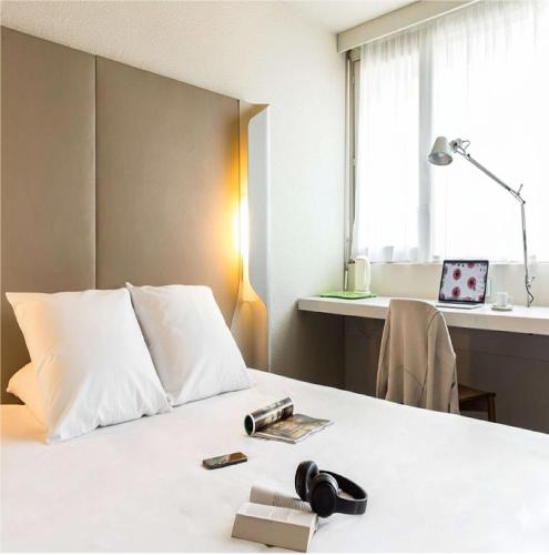 a hotel room with a bed and a desk at Campanile Conflans-Sainte-Honorine in Conflans-Sainte-Honorine