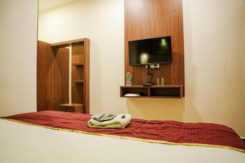 a bedroom with a bed with a tv on a wall at Qubehotelinn in Cochin