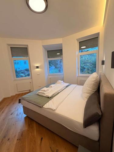 a large bed in a room with two windows at Ausblick apartments in Badenweiler