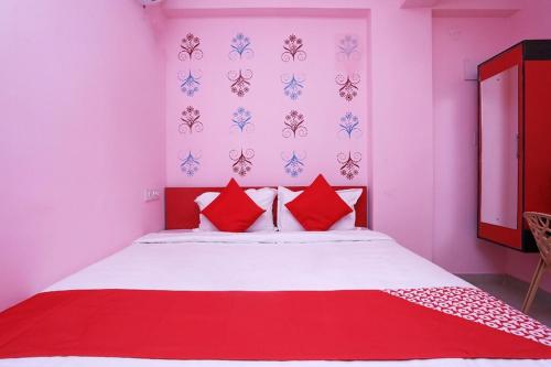 a bedroom with a large bed with red pillows at Star Hospitality in kolkata