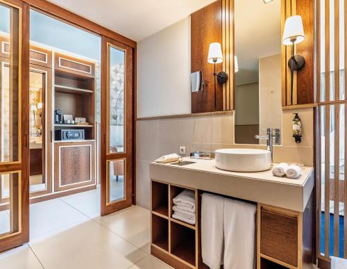 a bathroom with a sink and a mirror at Wine & Books by the Sea, Algarve Resort in Albufeira