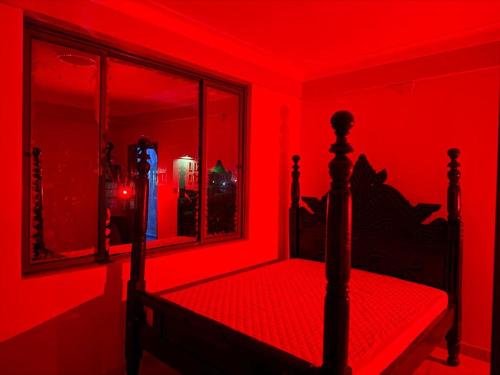 a bedroom with a red room with a bed and a mirror at Nordik Hotel in Nkumba
