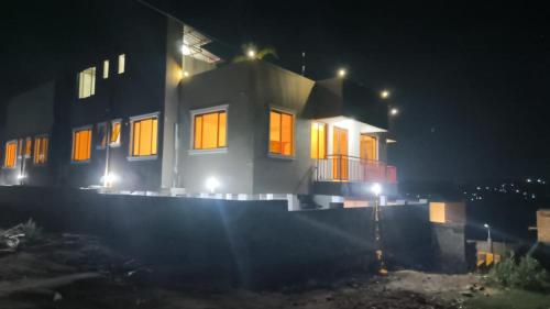 a house lit up at night with lights at Nordik Hotel in Nkumba
