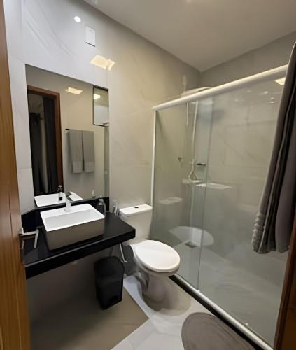 een badkamer met een toilet, een wastafel en een douche bij RM hospedagem unidade Amapá 2 in Cabo Frio
