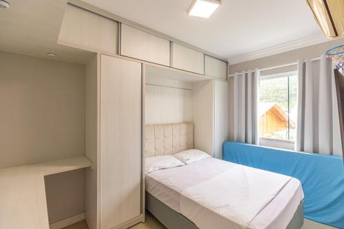 een kleine slaapkamer met een bed en een raam bij Village Eco Park in Bombinhas
