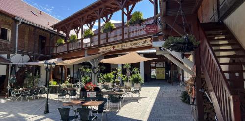 eine Außenterrasse mit Tischen, Stühlen und Sonnenschirmen in der Unterkunft Hotel Sonnekalb in Naumburg