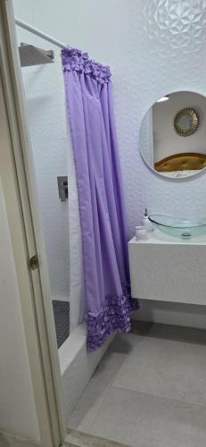 a bathroom with a purple shower curtain next to a sink at Martha's House Lexus in Soufrière