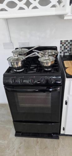 a stove with pots and pans on top of it at Martha's House Lexus in Soufrière