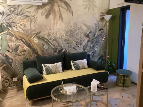 a living room with a couch and a mural at Guest house arboré in Saint-Loubès