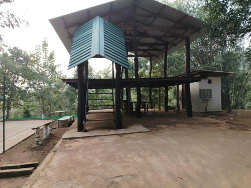 a pavilion with a blue object on top of it at Mur Farm House in Sonāpur