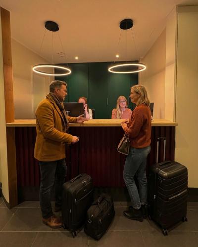 a man and a woman standing at a counter with luggage at Das Mühlentor Hotel mit Restaurant - moderne Zimmer - leckere Heimatküche - familiär geführt in Bad Kreuznach