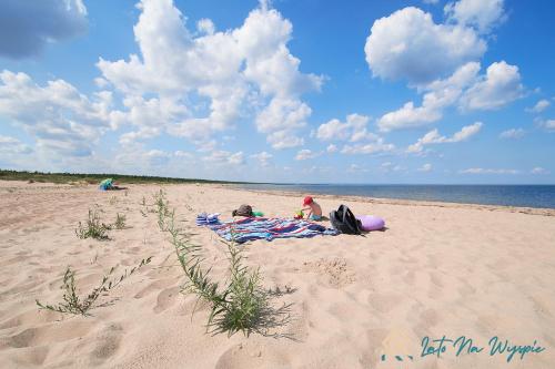 two people sitting on a blanket on the beach at LATO NA WYSPIE in Gdańsk
