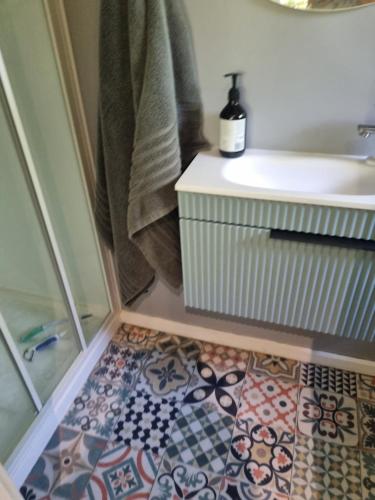 a bathroom with a sink and a tile floor at Norfolk House in Gisborne