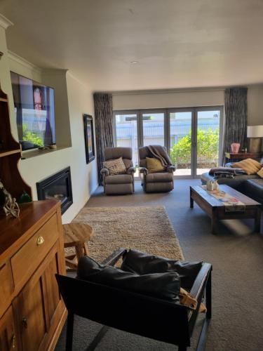 a living room with a couch and a table at Norfolk House in Gisborne