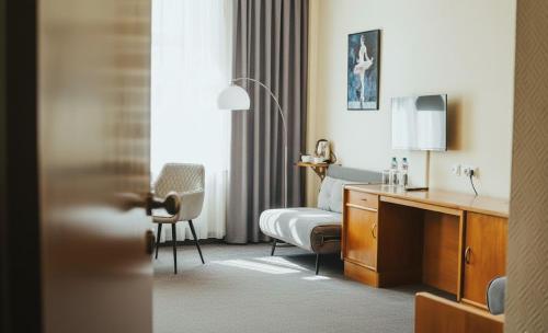 a hotel room with a bed and a desk at Hotel Polonia Racibórz in Racibórz