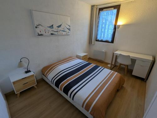 Central spacious flat with private parking في شامونيه مون بلان: غرفة نوم بها سرير ومكتب ونافذة
