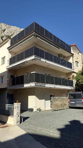 a large building with a parking lot in front of it at Apartments Neven in Omiš