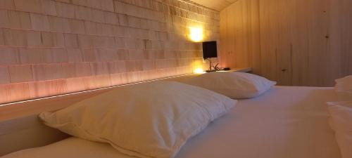 una camera da letto con due cuscini bianchi su un letto di Familienbauernhof Köss Schertler a Egg