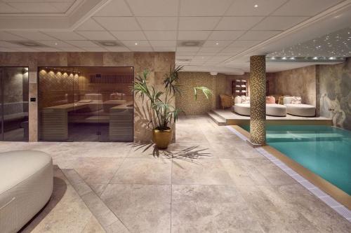 a hotel lobby with a pool and a bedroom at Van der Valk Palace Hotel Noordwijk in Noordwijk aan Zee