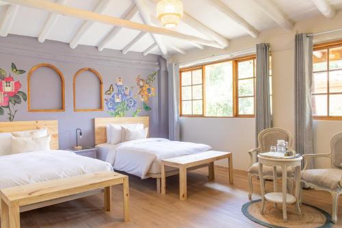 a bedroom with two beds and a chair at Tariq Sacred Valley in Urubamba