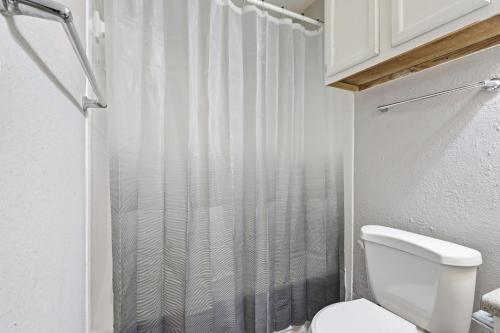a white bathroom with a shower curtain and a toilet at Comfortable 2BR2BA with Modern Touches in Jackson