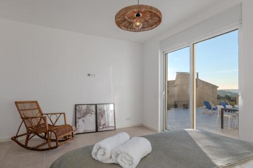 a bedroom with a bed and a chair and a window at Green House Zêzere in Souto