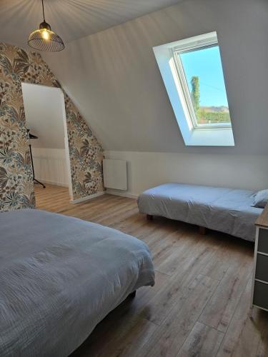 a bedroom with two beds and a window at Gîte Familial in Nabringhen