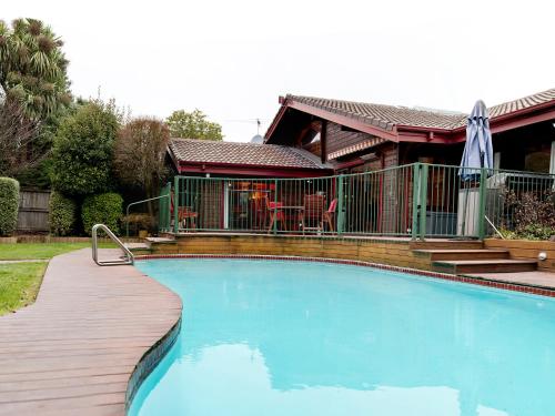 a large swimming pool in front of a house at Travellers Retreat B&B in Christchurch