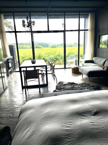 a bedroom with a bed and a couch and a large window at Loft industrial Colchagua in Santa Cruz