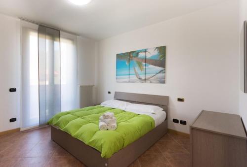 a bedroom with a bed with a green blanket at villa between lake and mountains in Valbrona