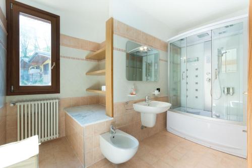 a bathroom with a tub and a sink and a toilet at villa between lake and mountains in Valbrona