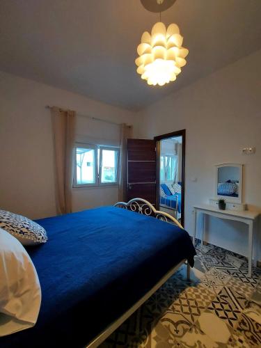 a bedroom with a blue bed and a chandelier at Calliope#2 in Skala