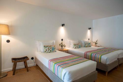 two beds in a room with white walls at Villa dos Corcéis in Esposende