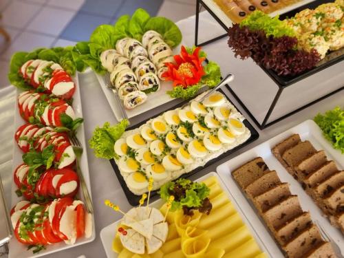 a table filled with different types of food on plates at Dom Wczasowy GLOBUS in Ustroń