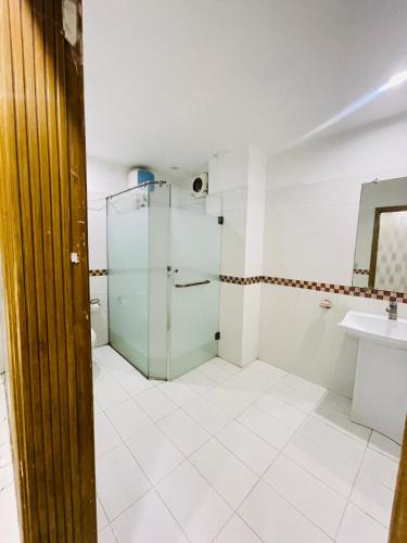a bathroom with a glass shower and a sink at Hotel Golden in Lahore
