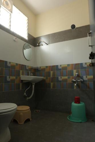 a bathroom with a toilet and a sink at SV Grand in Proddatūr