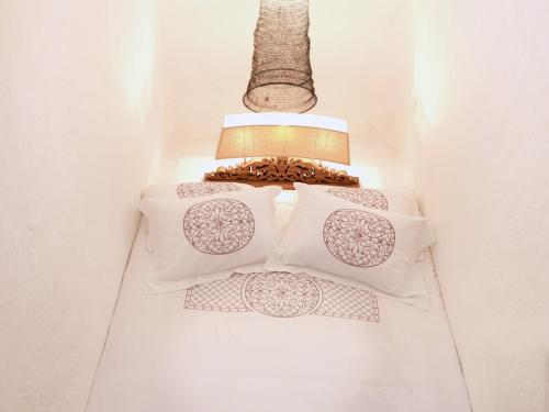 a row of white pillows on a shelf with a lamp at AFOURA HOUSES by K&K in Pyrgos
